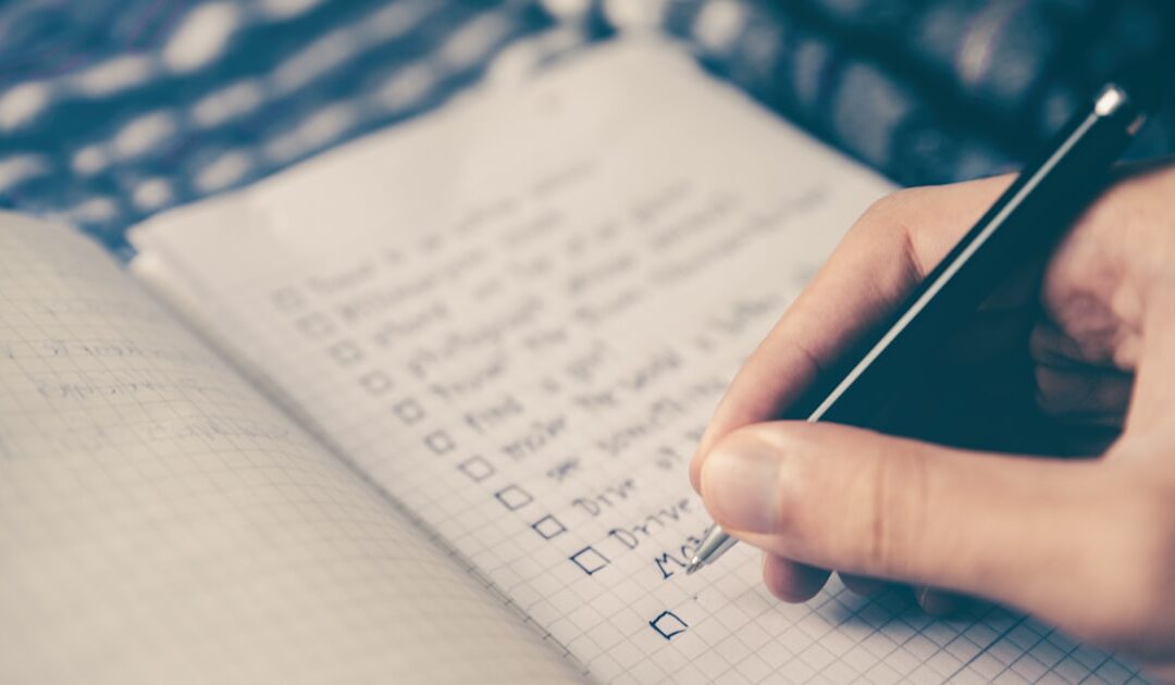 A handwritten list being worked through in a notebook