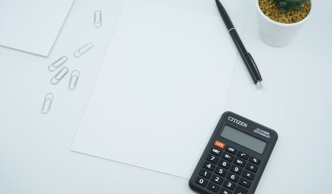 A calculator and pen on a printed ledger